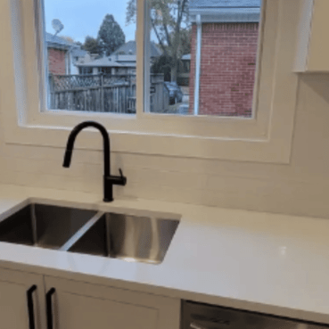 Kitchen counter with sink and faucet and window looking out on garden
